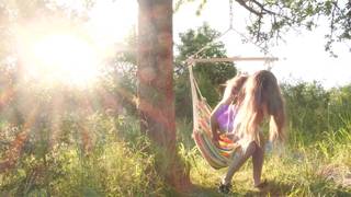 Chica desnuda masturbándose en una hamaca al aire libre